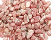 a pile of pink pebbles on a white surface