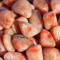 a pile of orange stones in a gold bowl