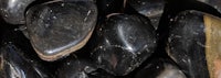 a close up of a pile of black stones