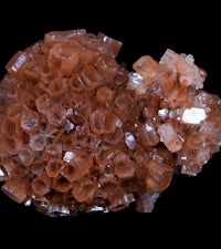 a cluster of orange crystals on a black background